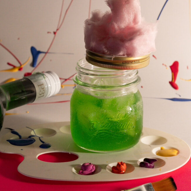 Cocktail Make Art a base di P31 Aperitivo Green con infuso di miele e agrumi, servito in barattolo con zucchero filato rosa, ricetta cocktail ispirato a Warhol e Pollock.